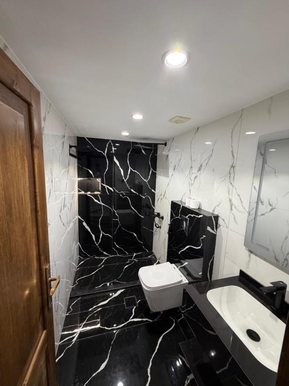a black and white bathroom with a toilet and a sink at Hamod in Wadi Rum