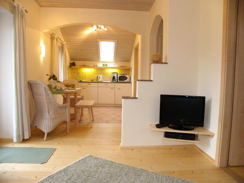 a living room with a tv and a kitchen at Ferienwohnung Zwiesel in Wackersberg