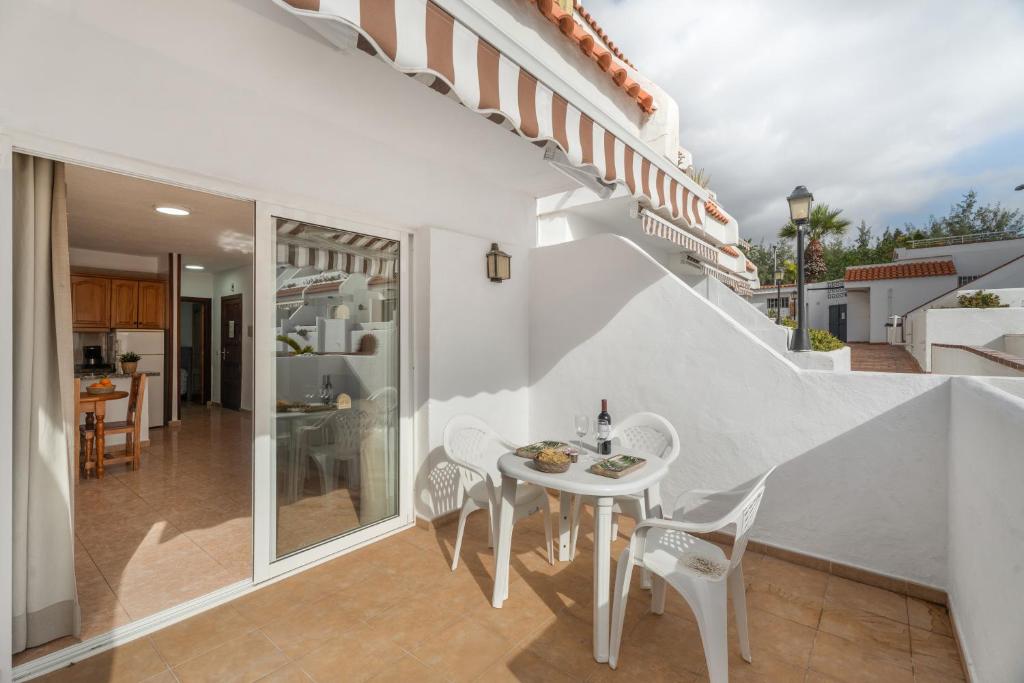 a white dining room with a table and chairs at Sun and Calm Las Floritas in Playa de las Americas
