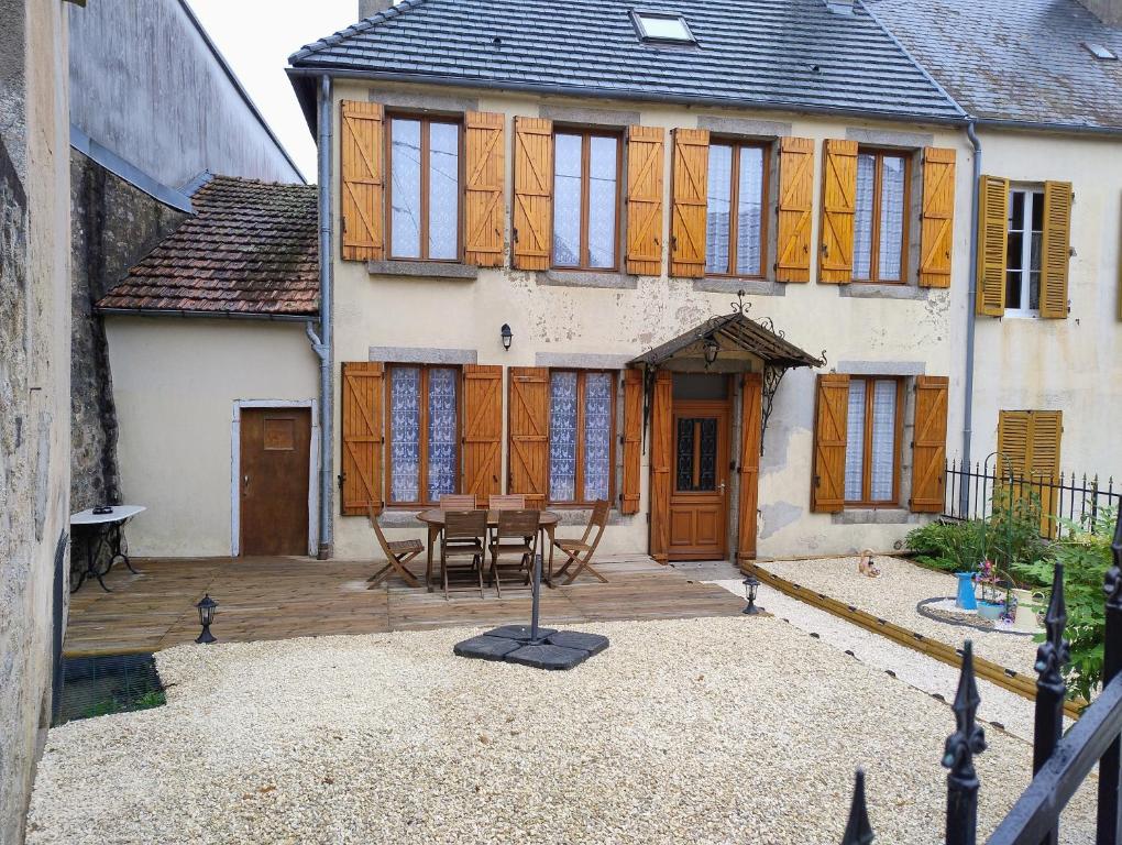 a house with a patio with a table in front of it at Gite cozy, Parc naturel du Morvan in Lormes