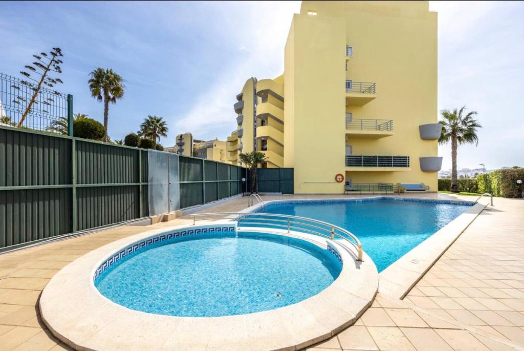 a swimming pool in front of a building at Casa Cláudia - Cond do Mar in Lagos