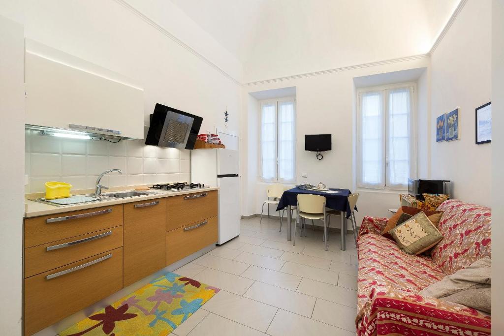 a kitchen and a living room with a couch at Smart Home Loano in Loano