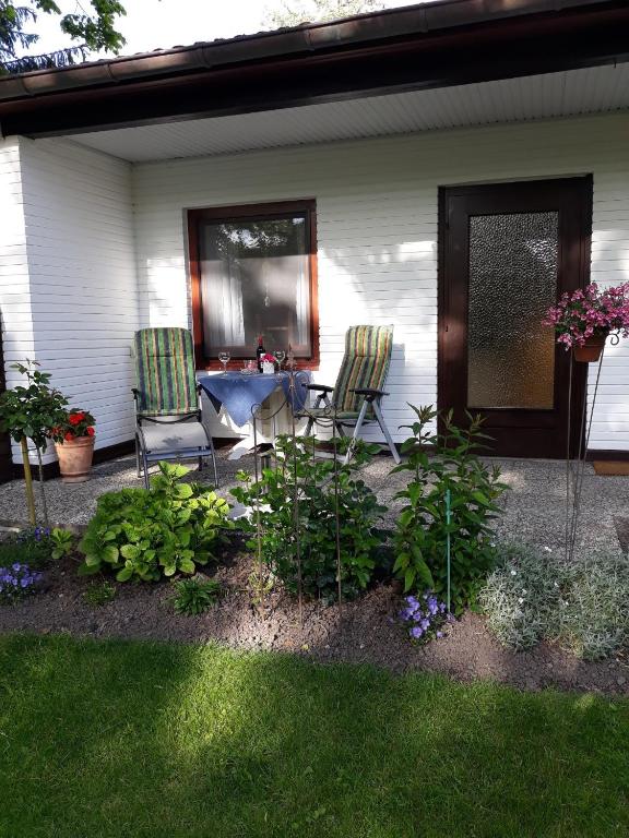 two chairs and a table outside of a house at Ferienwohnung 'unter Der Linde' in Neuenkirchen
