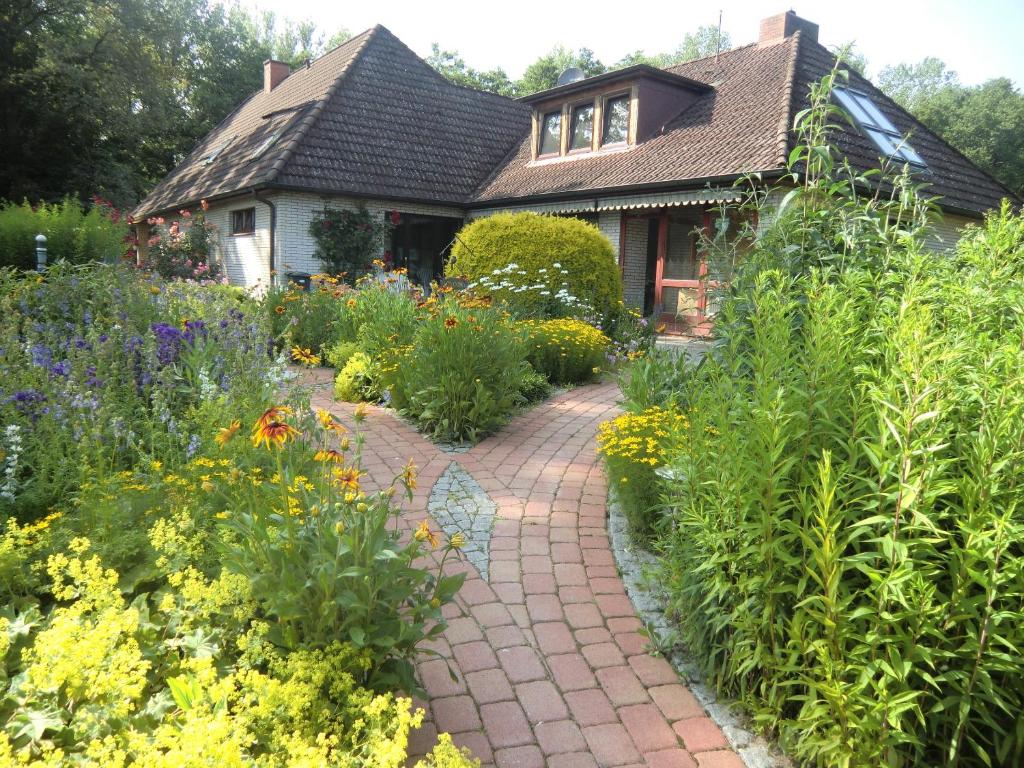 a garden with a brick walkway in front of a house at Fewo Birkenallee - Apfel in Deinste
