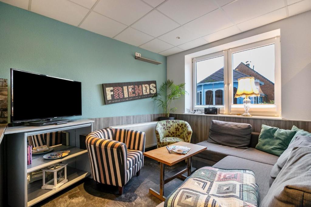 a living room with a couch and a tv at Klönstuv in Breklum