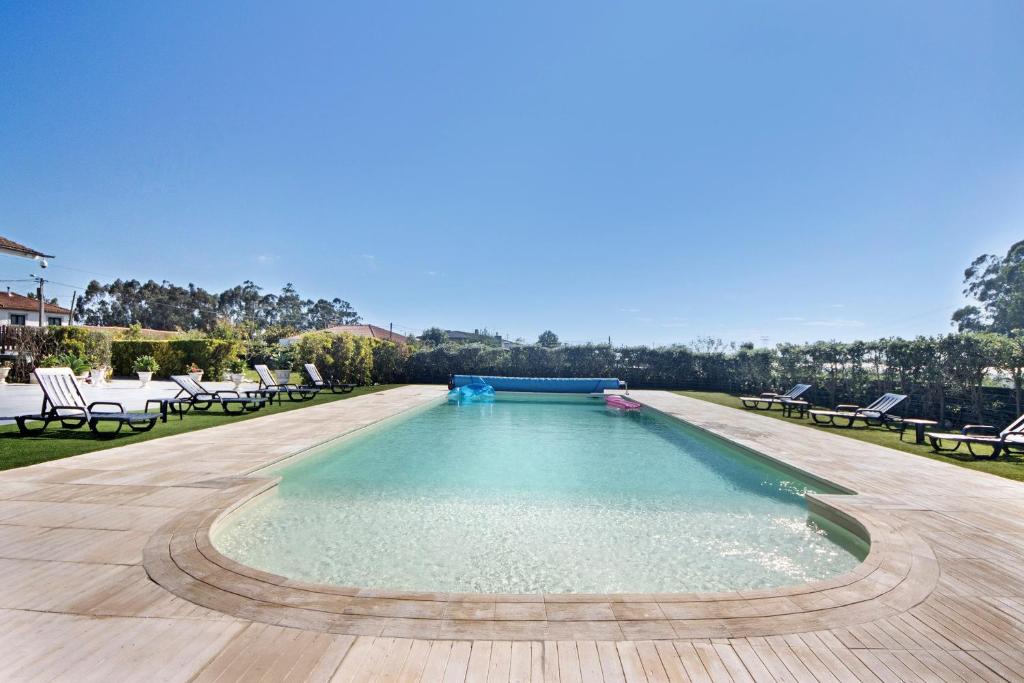 a swimming pool with lounge chairs and a swimming pool at Apartamento Lomi com Piscina in Apúlia