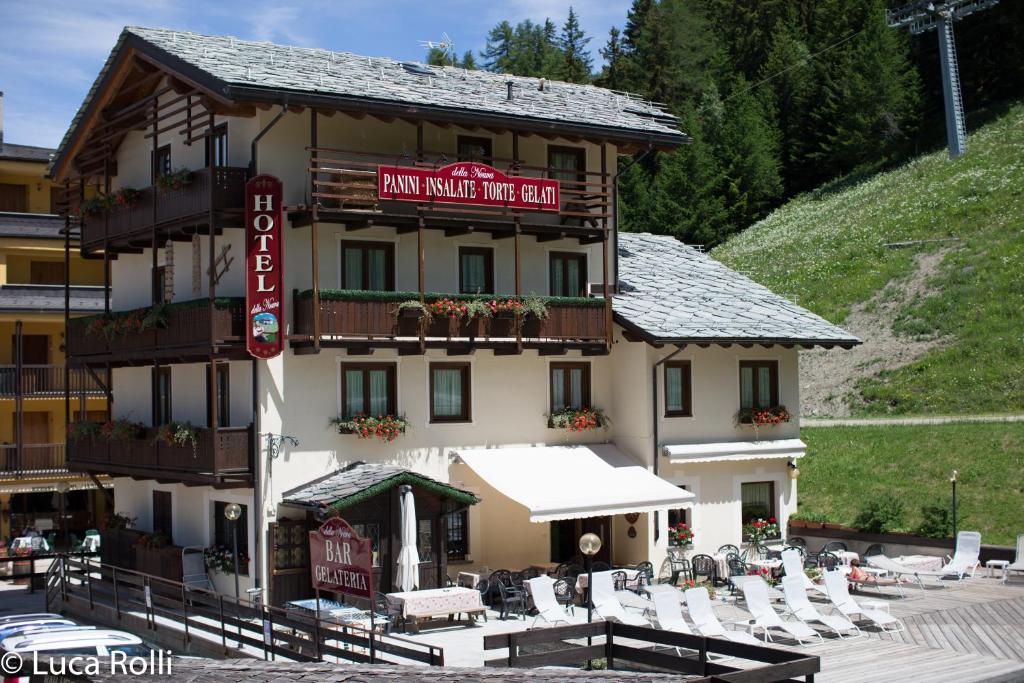 a large building with chairs in front of it at Hotel Della Nouva in Pila