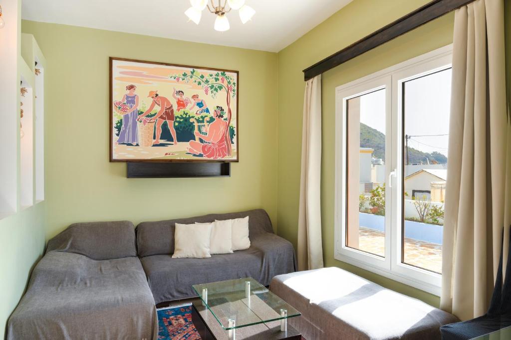 a living room with a couch and a window at Anemi Leros Apartments 1 in Panteli