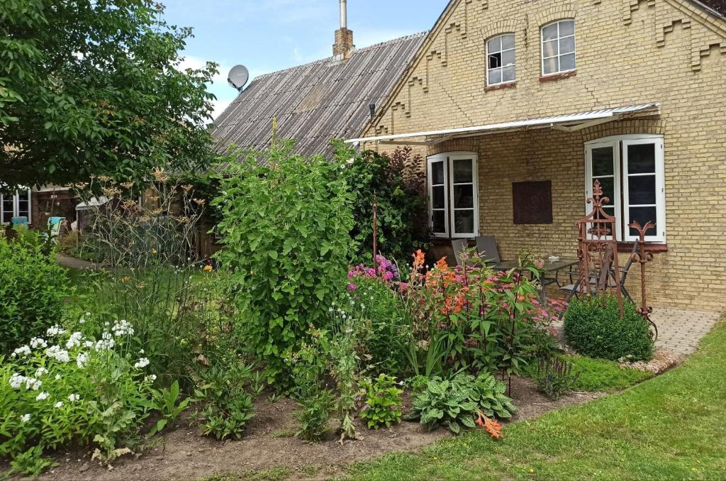 a garden in front of a house with flowers at Ferienwohnung Klint 2 in Dellstedt