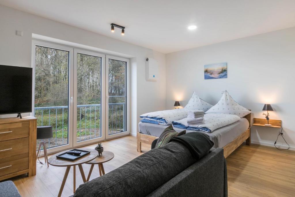a living room with a couch and a bed at Hodderup Wohnung 10 in Husby