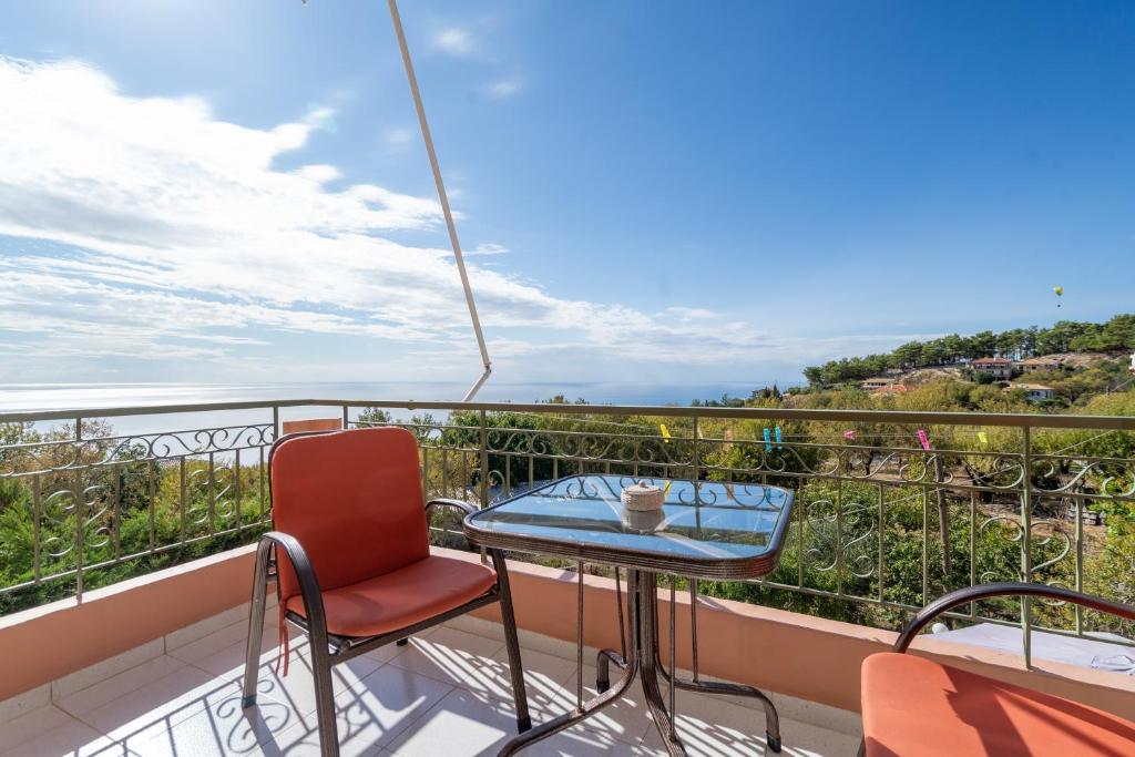 a table and chairs on a balcony with a view at Nontas Home 21 in Kalamitsi