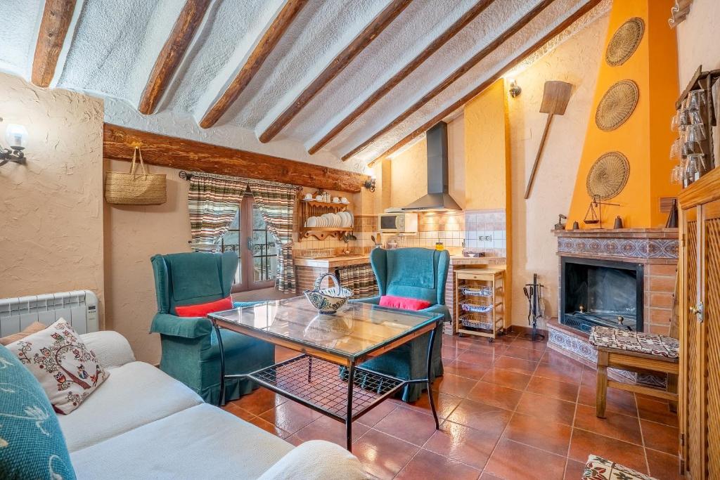 a living room with a table and chairs and a fireplace at Romero in Hinojares