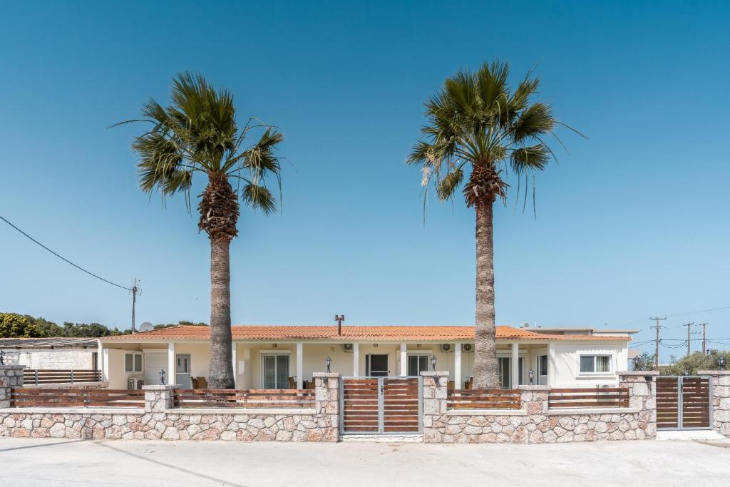 two palm trees in front of a house at Absinthia Fanes in Rhodes Town