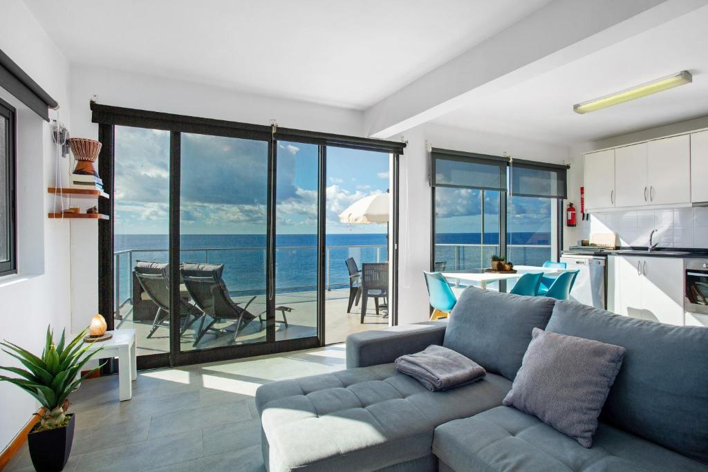 a living room with a couch and a view of the ocean at The Wave House - Two Bedroom Flat in Jardim do Mar