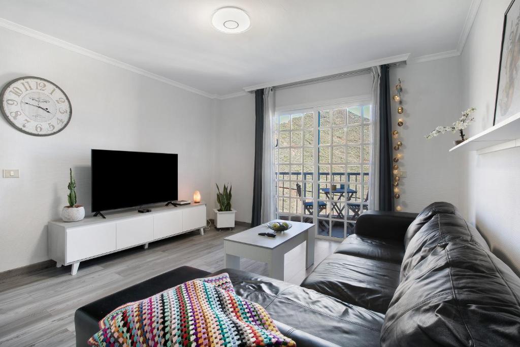 a living room with a couch and a tv at Las Teresitas Beach Apartment in San Andrés