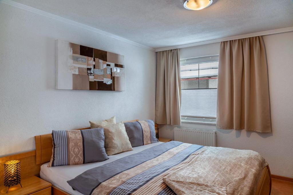 a bedroom with a large bed with a window at Apart Bergtraum Ried - Typ 2 in Ried im Oberinntal