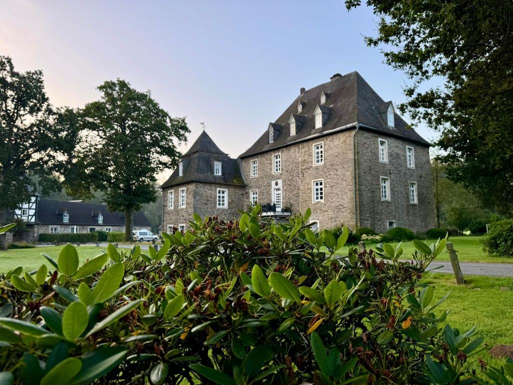 an old brick building with a black roof at Gut Wenne in Eslohe