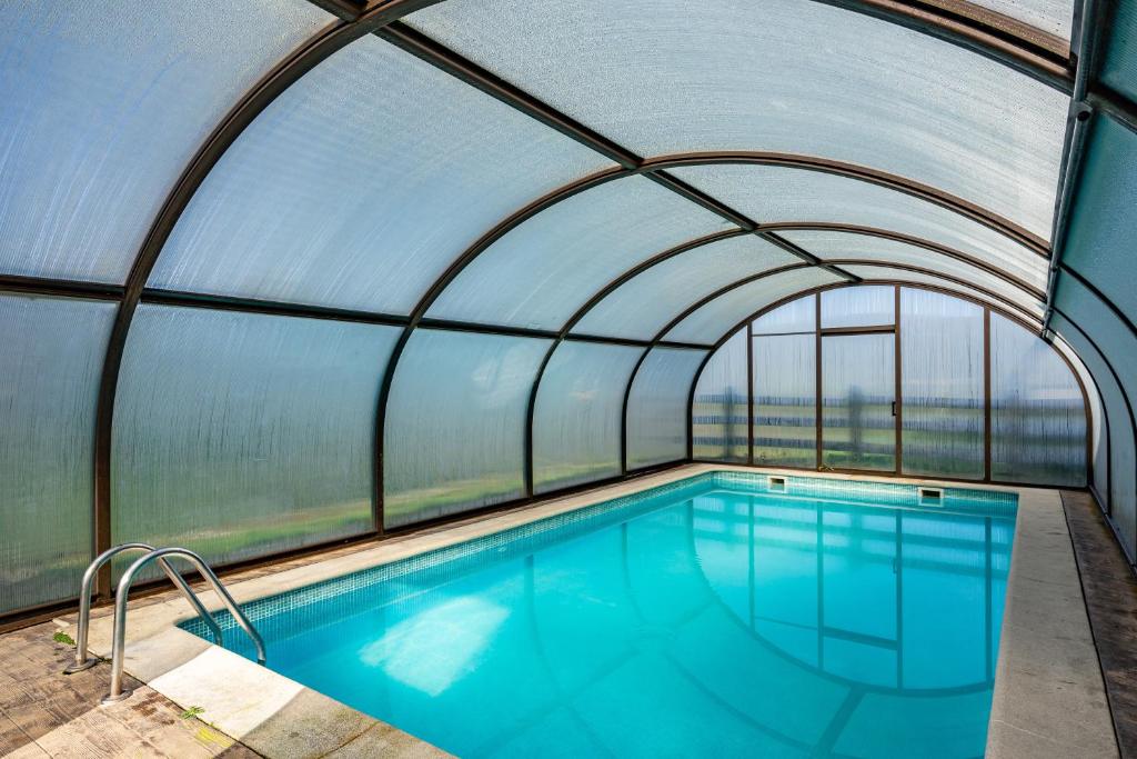 an indoor swimming pool with an arched ceiling at La Posada Del Chano in Cerecedo de Besullo
