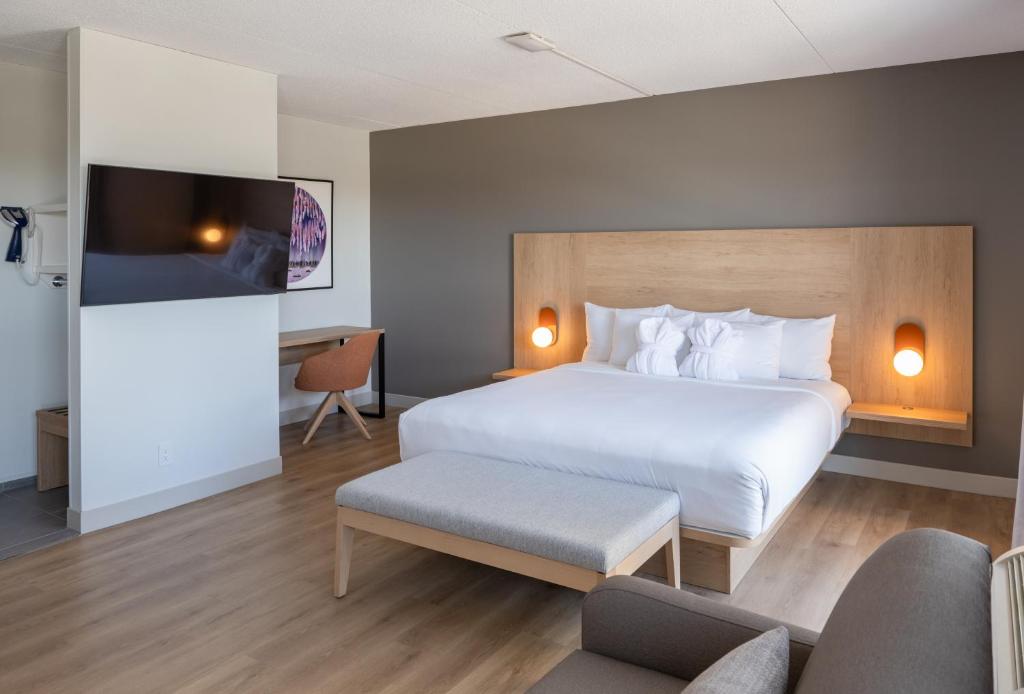 a hotel room with a bed and a tv at Norwood Hotel in Winnipeg