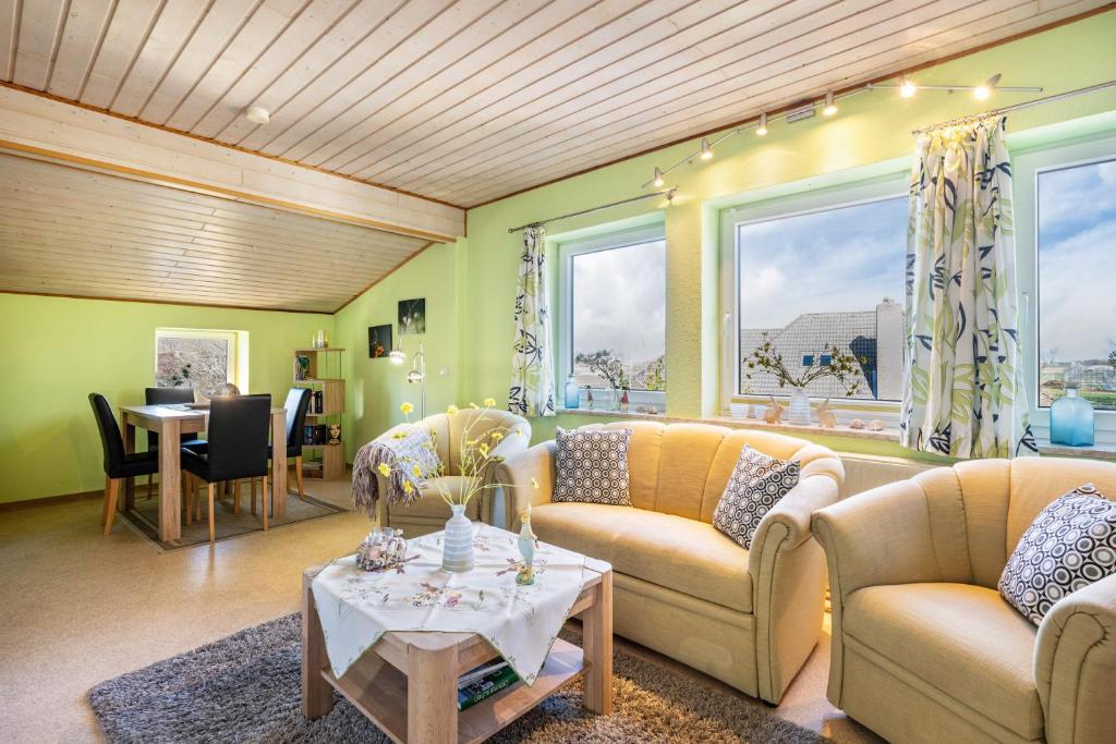a living room with two couches and a table at Fluss aufwärts in Schülp