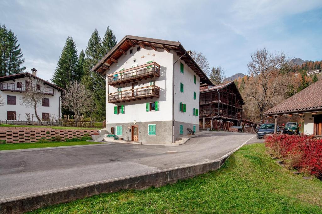 a large white building on the side of a road at Appartamento Zopel in Falcade