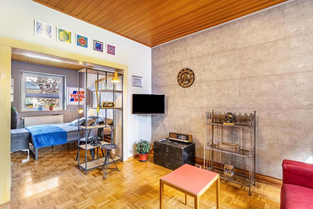 a living room with a bed and a television at Happy Place Indu Style in Korbach