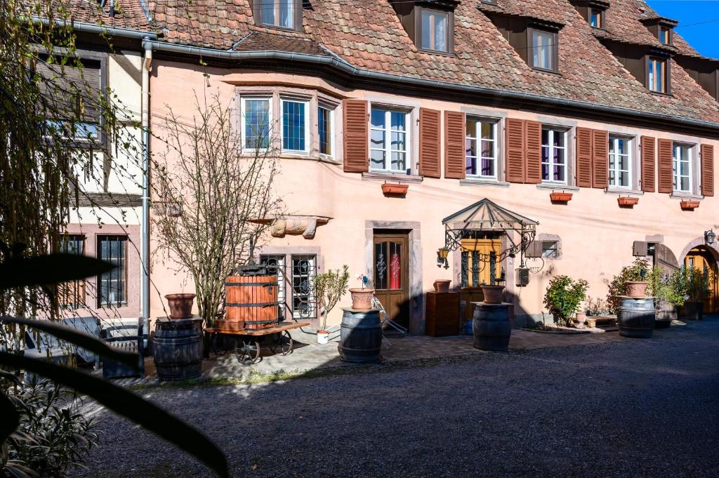 a large pink building with pots in front of it at Demeure D'antan - Chambres d'hôtes in Beblenheim