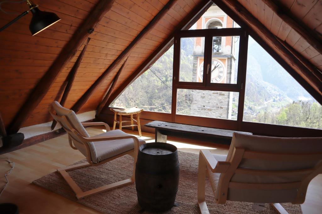 a room with two chairs and a large window at Casa Elena Rustico storico a Corippo in Corippo