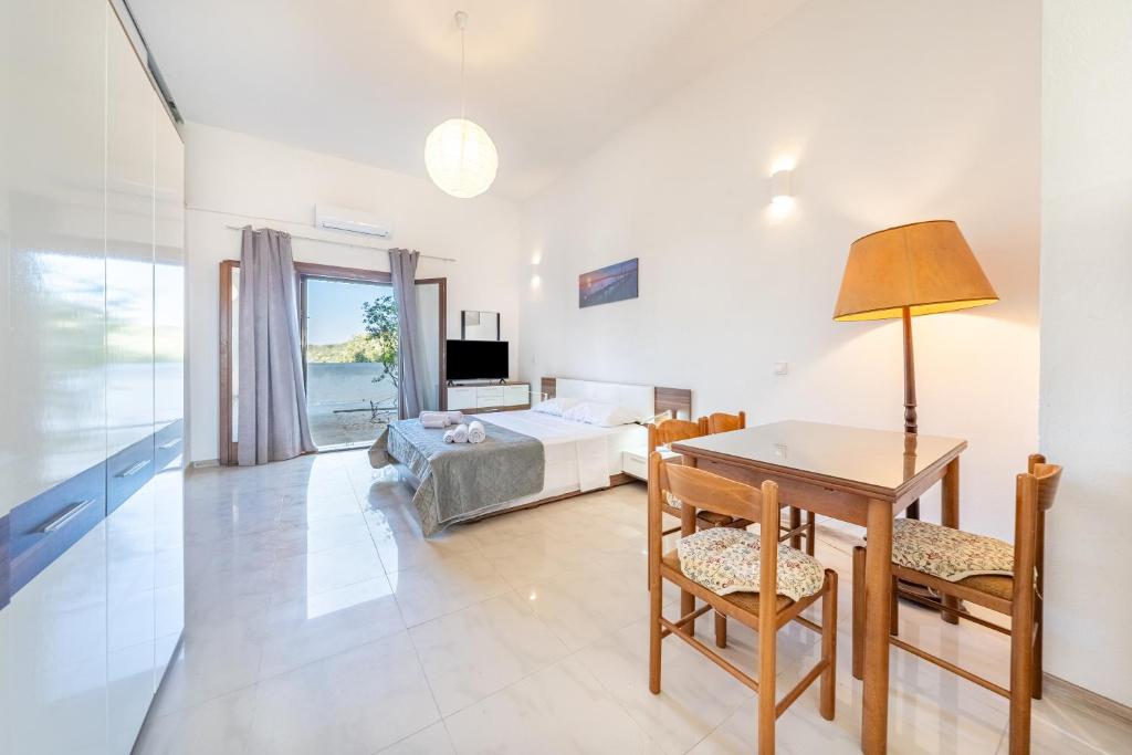 a bedroom with a bed and a table and a desk at Melissa apartments in Halikounas