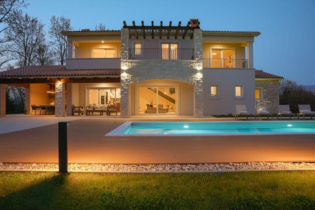 a large house with a swimming pool in front of it at Villa Lapidea in Bezjaki