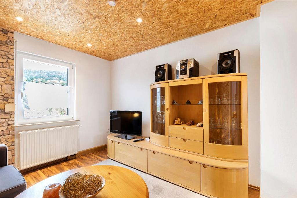 a living room with a tv and a wooden cabinet at Ferienwohnung Nickel in Hofstetten