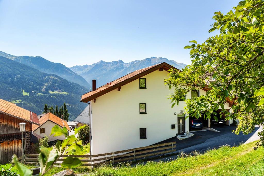 a white house with mountains in the background at Manu's Bergblick in Arzl im Pitztal