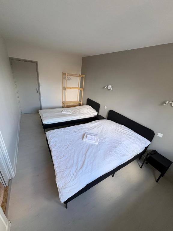 a bedroom with a large bed with white sheets at Hôtel café des cours in Cébazat