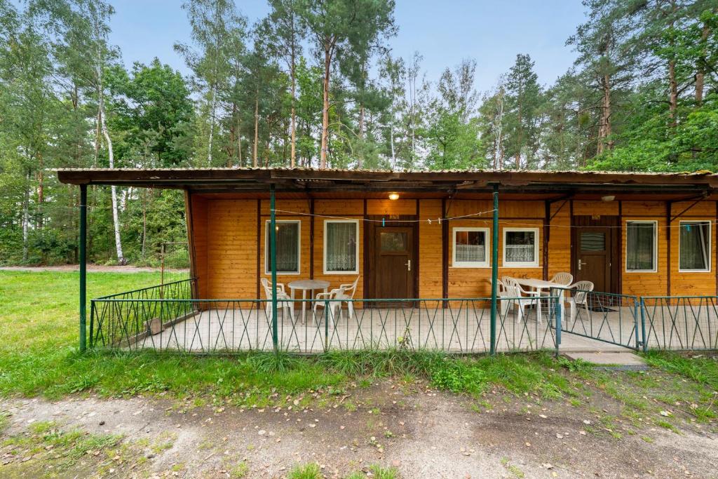 a cabin in the woods with a porch and chairs at Bungalow 37b - Kimbucht in Reichendorf