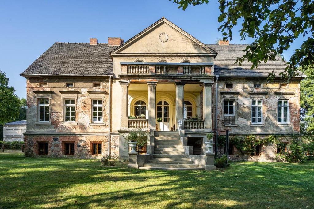 an old stone house with a large yard at Ferienwohnung im Landschloss in Calau