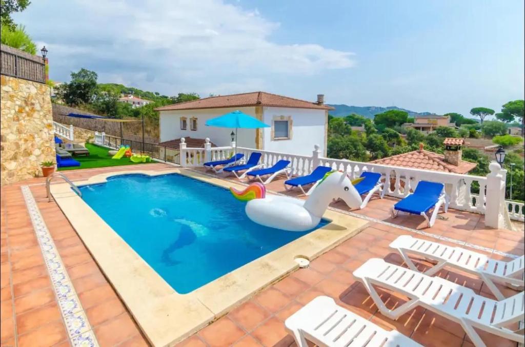 a swimming pool with chairs and an inflatable slide at Villa Mansory in Lloret de Mar