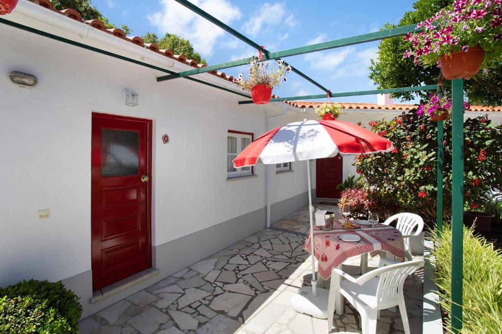 a patio with a table and an umbrella at Páteo da Várzea 2 in Colares