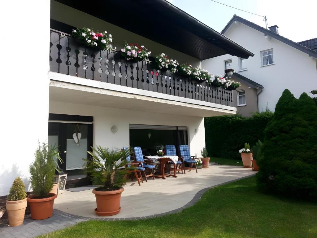 a house with a balcony with a table and chairs at Ferienwohnung Poll in Wimbach