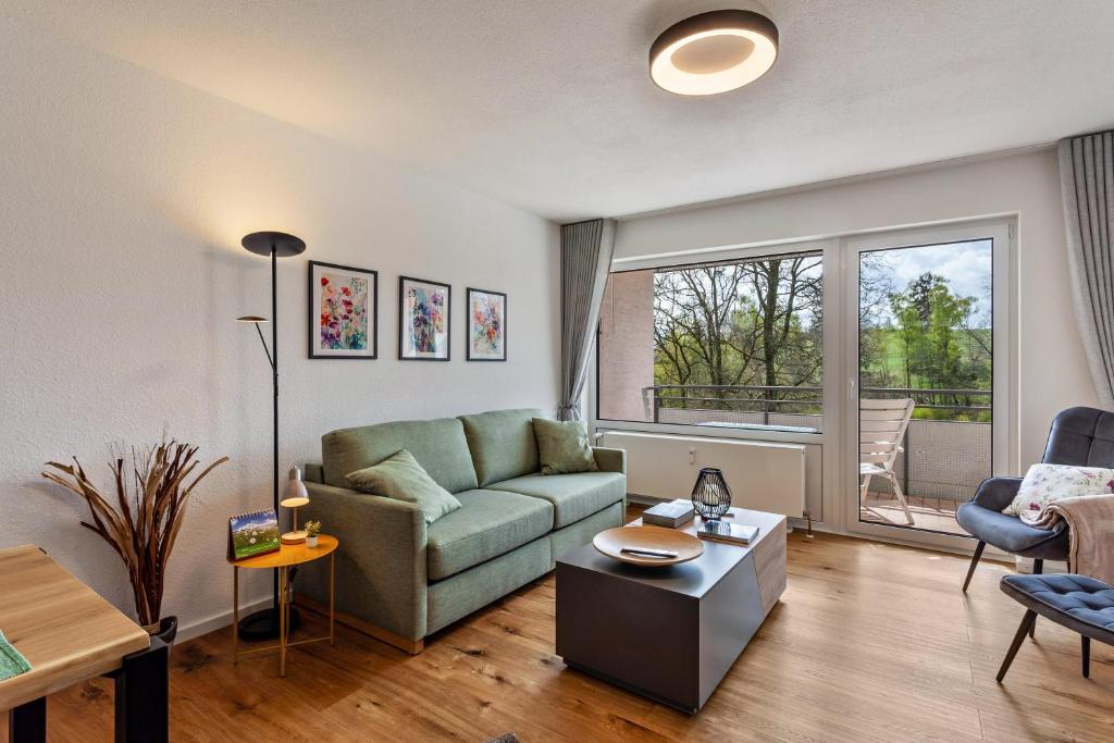 a living room with a couch and a table at Berg und Tal Apartment in Brilon