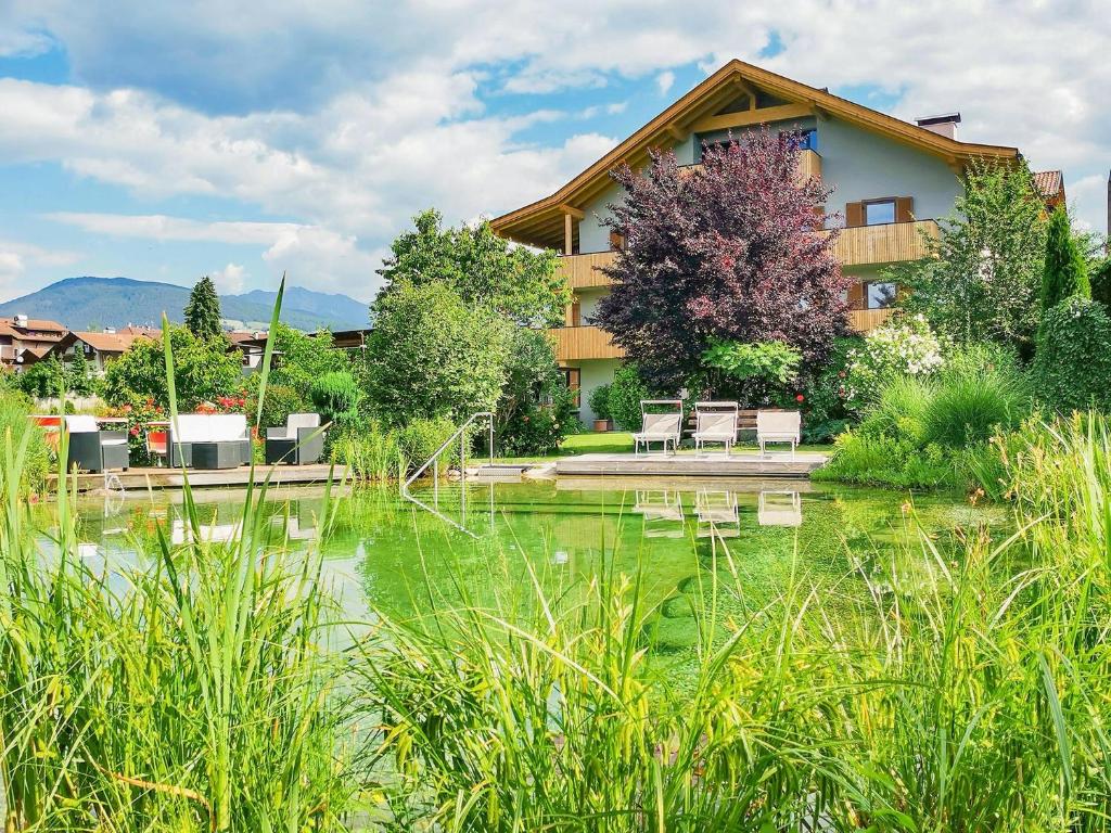 a building with a pond in front of it at Residence Linderhof in Natz-Schabs