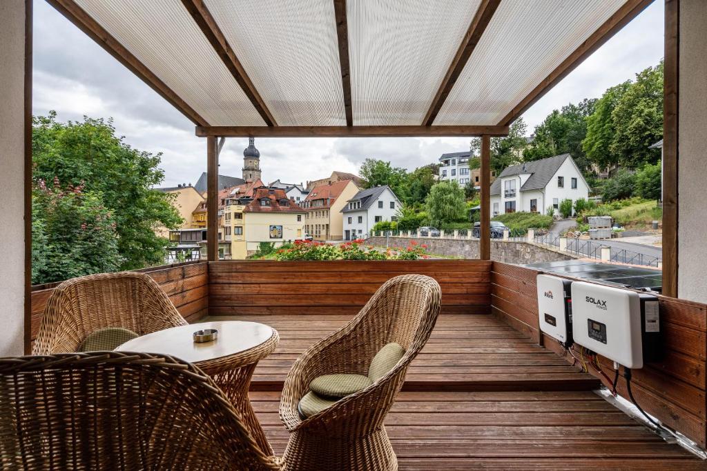 a balcony with chairs and a table on a wooden deck at Ferienwohnung am Residenzschloss in Altenburg