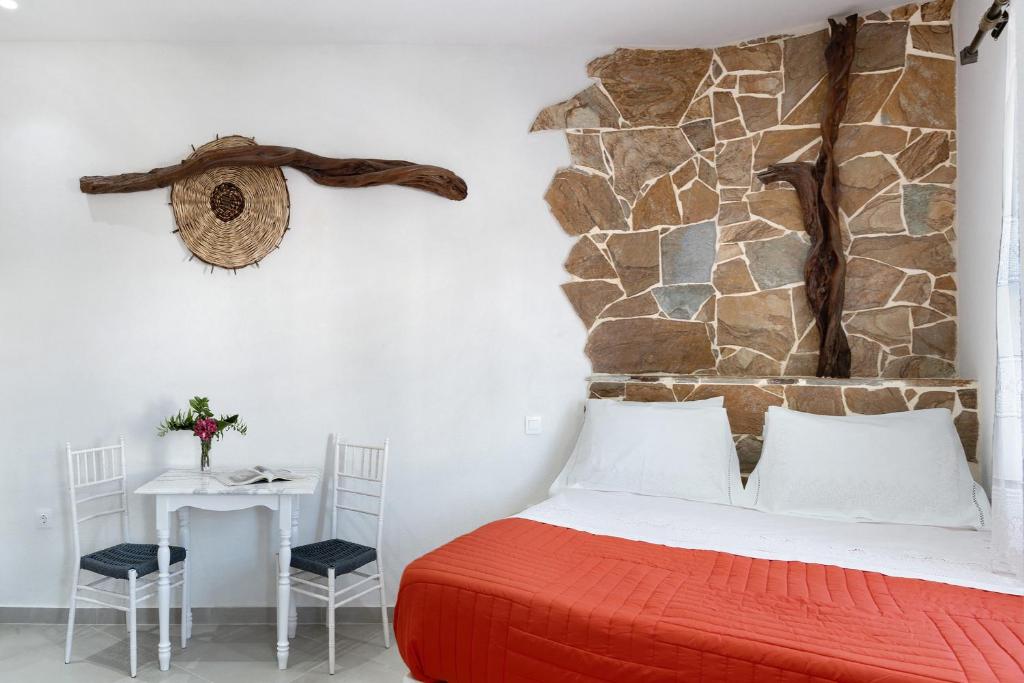 a bedroom with a bed and a stone wall at Politimis Studio N1 in Amorgos