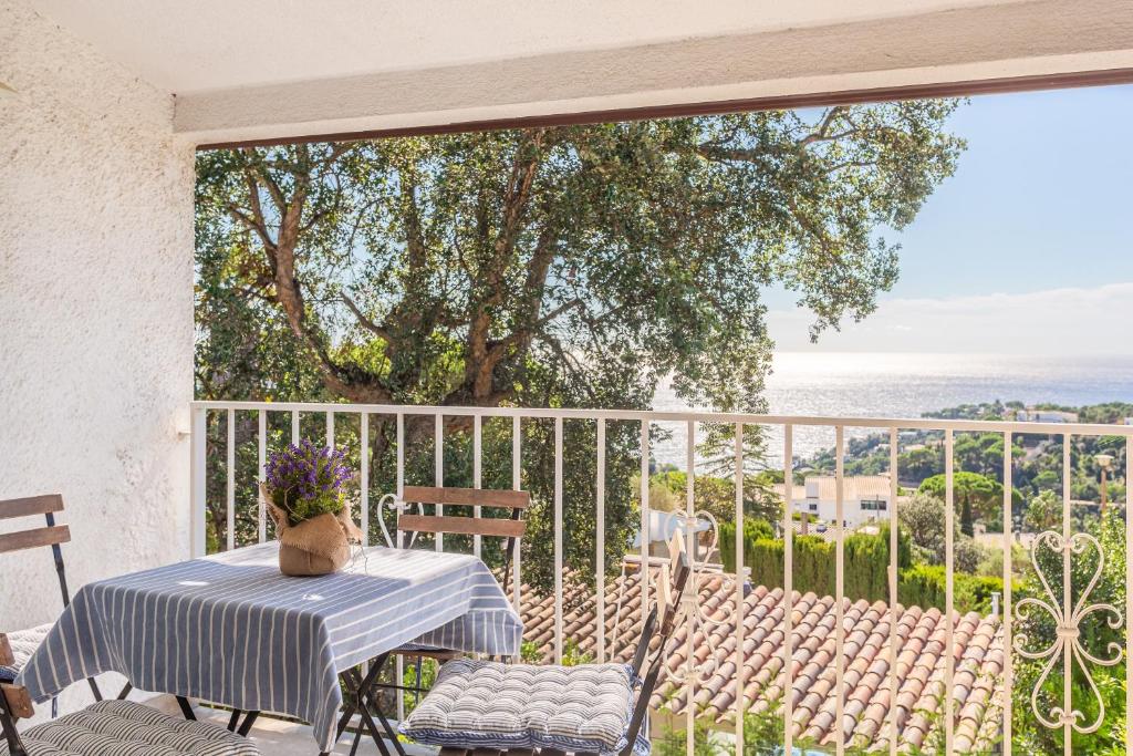 a table and chairs on a balcony with a view of the ocean at Casa Yves in Tossa de Mar