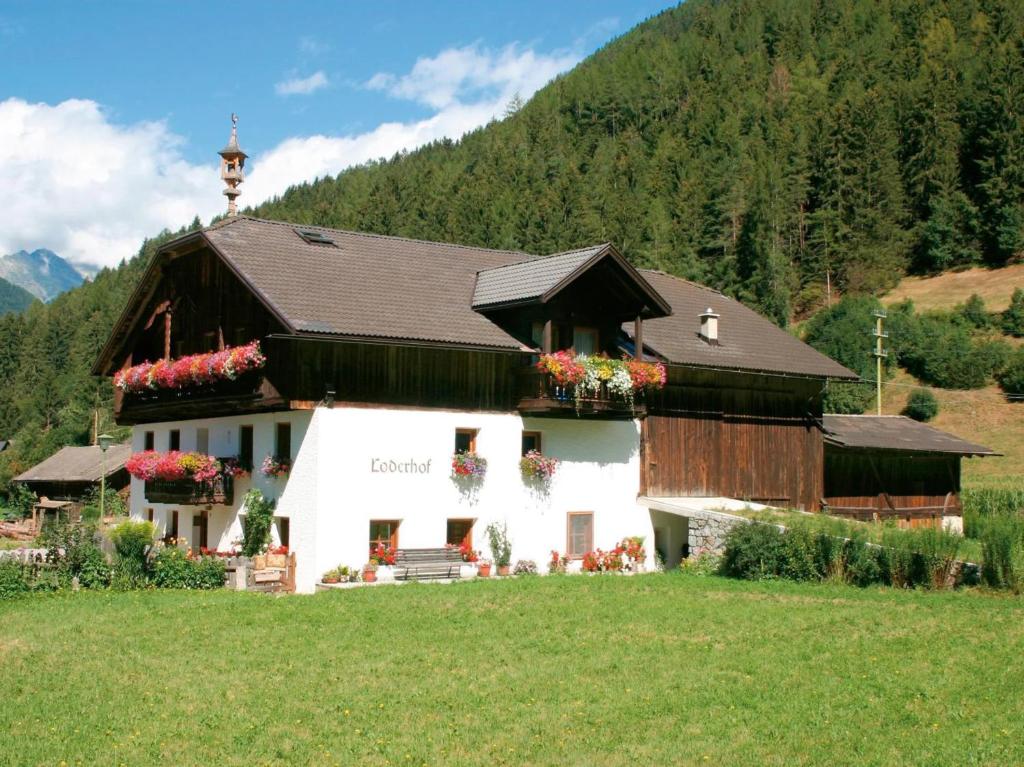 a house in a field with flowers on it at Loderhof Sand in Taufers in Sand in Taufers