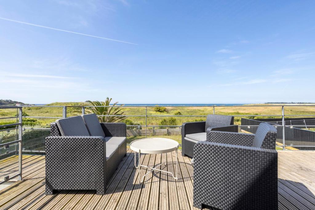 two chairs and a table on a deck with a view at Maison Horizon - 3 ch - 100m plage in Le Guilvinec