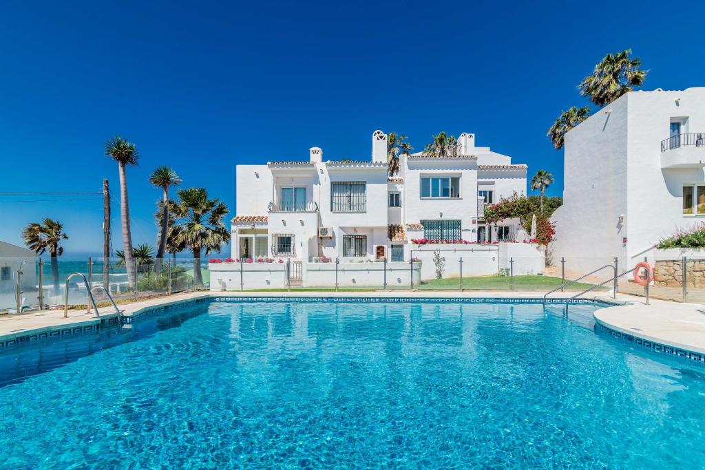 a large swimming pool in front of a white house at Rocas del Mar in Mijas