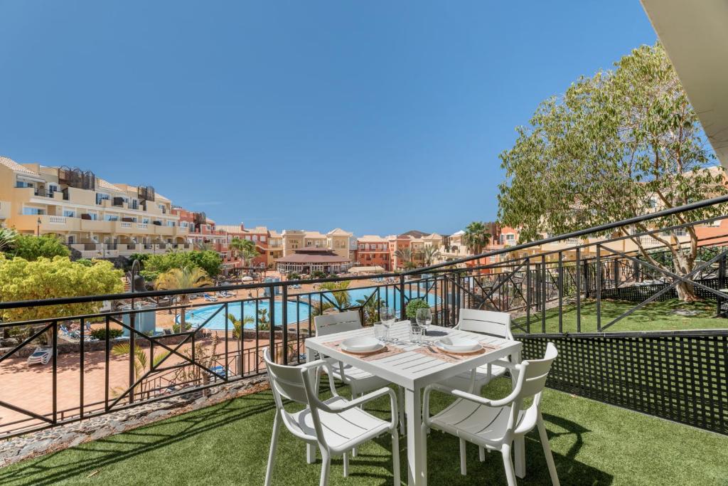 a table and chairs on a balcony with a view of the water at Granada Park S01A in Arona