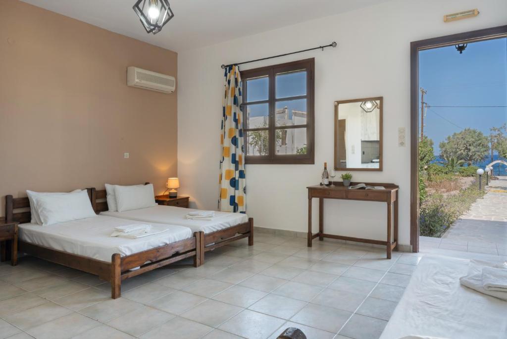 a bedroom with a bed and a table and a window at Frantzis Studio 2 - Nisyros in Páloi