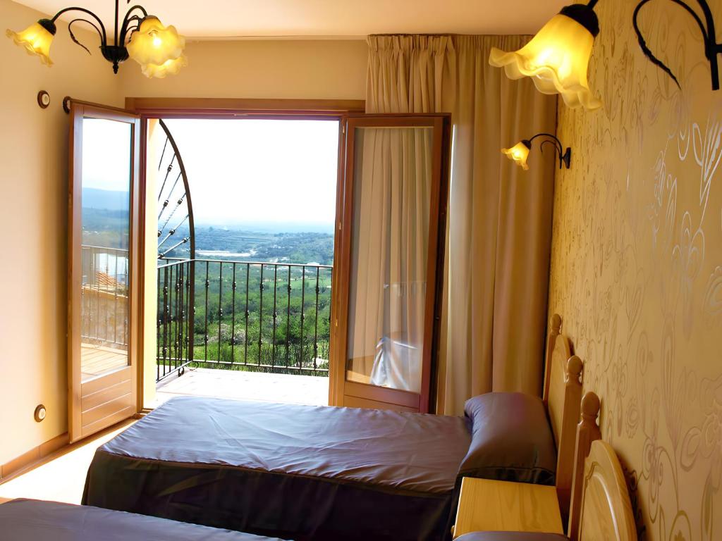 a bedroom with a bed and a large window at Can Joan in Rosell