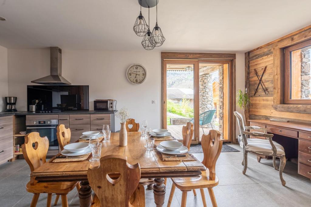 a dining room with a wooden table and chairs at La cabane du cerf in Les Allues